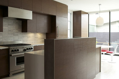 This is an example of a modern galley eat-in kitchen in San Francisco with flat-panel cabinets, dark wood cabinets and grey splashback.