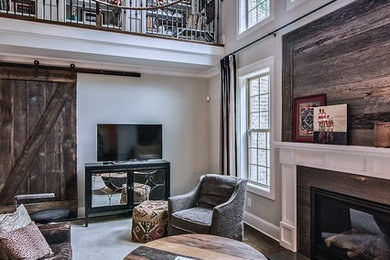 Mid-sized country formal loft-style living room in Charlotte with grey walls, dark hardwood floors, a standard fireplace, a stone fireplace surround, a freestanding tv and brown floor.