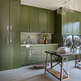Diseño de cuarto de lavado lineal, actual, grande, con fregadero bajoencimera, armarios con paneles lisos, puertas de armario verdes, encimera de cuarzo compacto, suelo de baldosas de porcelana, lavadora y secadora juntas, suelo gris y encimeras blancas