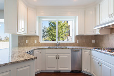 Small transitional u-shaped eat-in kitchen in Salt Lake City with a drop-in sink, raised-panel cabinets, white cabinets, stainless steel appliances, dark hardwood floors and no island.