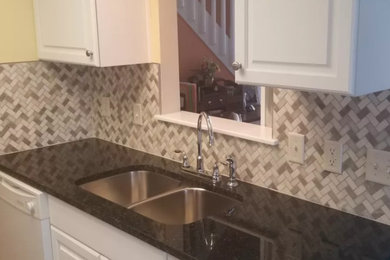 Inspiration for a mid-sized timeless kitchen remodel in Other with a double-bowl sink, raised-panel cabinets, white cabinets, granite countertops, gray backsplash, marble backsplash and brown countertops