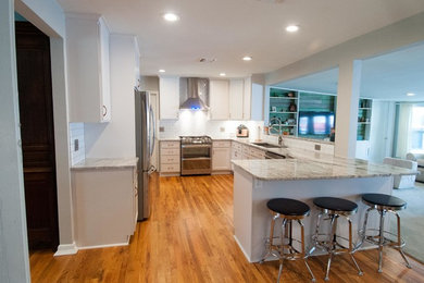 Example of a large classic u-shaped medium tone wood floor and multicolored floor eat-in kitchen design in Austin with shaker cabinets, white cabinets, granite countertops, white backsplash, subway tile backsplash, stainless steel appliances and a peninsula