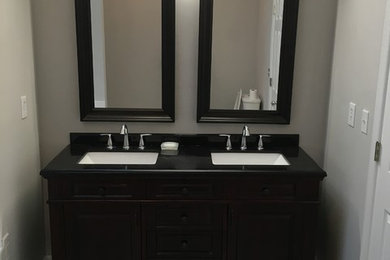 Example of a large classic master gray tile and ceramic tile ceramic tile alcove shower design in DC Metro with recessed-panel cabinets, black cabinets, a hot tub, a two-piece toilet, beige walls, a wall-mount sink and granite countertops