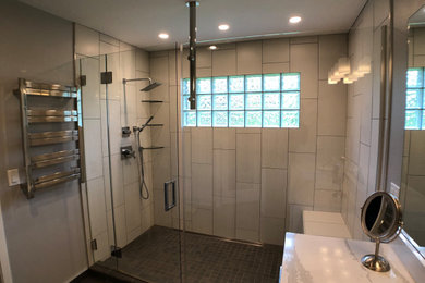 Example of a trendy master gray floor and single-sink bathroom design in Cedar Rapids with flat-panel cabinets, white cabinets, a one-piece toilet, gray walls, an undermount sink, quartz countertops, a hinged shower door, white countertops and a freestanding vanity