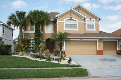 Design ideas for a large traditional two-storey stucco beige exterior in Orlando with a gable roof.