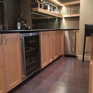 Inspiration for a large modern u-shaped breakfast bar in Philadelphia with shaker cabinets, light wood cabinets, composite countertops, black splashback, dark hardwood flooring, brown floors and black worktops.