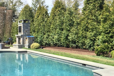 Mid-sized traditional backyard custom-shaped lap pool in New York with concrete pavers.