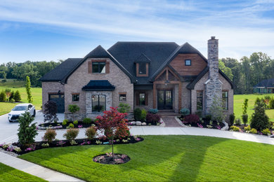 Huge arts and crafts multicolored two-story wood house exterior photo in Cincinnati with a hip roof and a mixed material roof