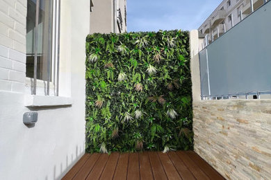 Cette image montre une petite terrasse au rez-de-chaussée minimaliste avec une cour et un garde-corps en métal.