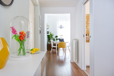 This is an example of a mid-sized scandinavian hallway in Rome with white walls, medium hardwood floors and brown floor.