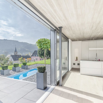 Offene Wohnküche mit Schiebetür in den Garten