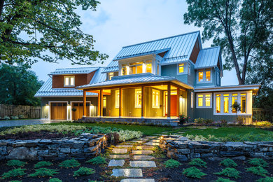 Large farmhouse green two-story wood exterior home idea in Ottawa with a metal roof