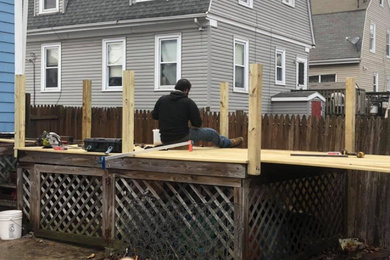 Mid-sized backyard ground level wood railing deck photo in Boston with no cover