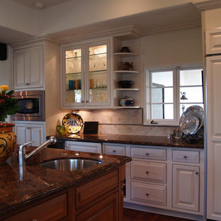 Mid-sized traditional kitchen pantry ideas - Mid-sized elegant u-shaped medium tone wood floor kitchen pantry photo in Santa Barbara with a double-bowl sink, beaded inset cabinets, white cabinets, granite countertops, multicolored backsplash, paneled appliances and an island