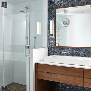 Foto di una stanza da bagno padronale moderna con ante lisce, ante in legno scuro, vasca freestanding, doccia ad angolo, WC a due pezzi, piastrelle nere, piastrelle di vetro, pareti bianche, pavimento in gres porcellanato, lavabo rettangolare e top in quarzo composito