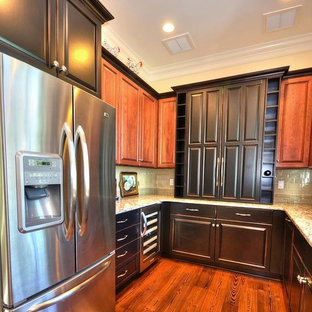 Small traditional kitchen pantry pictures - Inspiration for a small timeless u-shaped medium tone wood floor and brown floor kitchen pantry remodel in Wilmington with an undermount sink, raised-panel cabinets, black cabinets, quartz countertops, beige backsplash, glass tile backsplash and stainless steel appliances