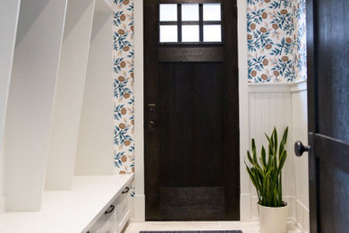 Photo of a mid-sized traditional mudroom in Other with a single front door and a dark wood front door.