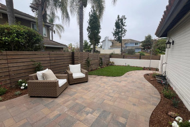 Example of an arts and crafts backyard concrete paver patio design in San Diego with no cover