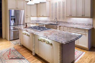 Kitchen - traditional l-shaped light wood floor kitchen idea in Houston with a farmhouse sink, recessed-panel cabinets, granite countertops, beige backsplash, stone tile backsplash and an island