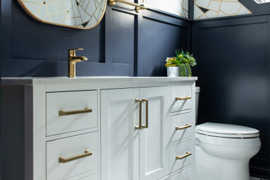 Mid-sized transitional porcelain tile, white floor and wallpaper powder room photo in Chicago with shaker cabinets, white cabinets, a two-piece toilet, blue walls, an undermount sink, marble countertops, white countertops and a freestanding vanity