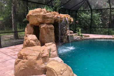 Mountain style backyard custom-shaped natural pool photo in Tampa