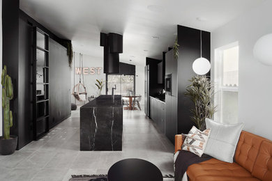 Diseño de cocina moderna con armarios con paneles lisos, puertas de armario negras, una isla, suelo gris, encimeras negras y encimera de mármol