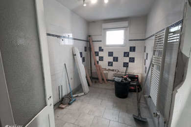 Réalisation d'une salle de bain design avec des portes de placard blanches.