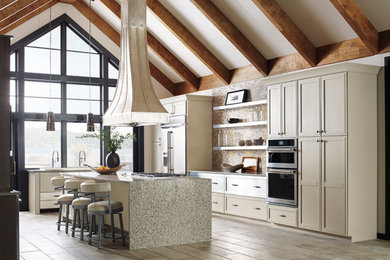 Huge elegant light wood floor and brown floor eat-in kitchen photo in Boston with shaker cabinets, white cabinets, stainless steel appliances, an island and gray countertops