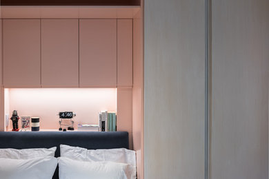This is an example of a small modern master bedroom in New York with pink walls and dark hardwood floors.