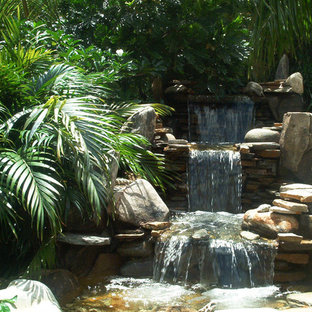 Großes Asiatisches Sportbecken hinter dem Haus in rechteckiger Form mit Wasserspiel und Natursteinplatten in Miami