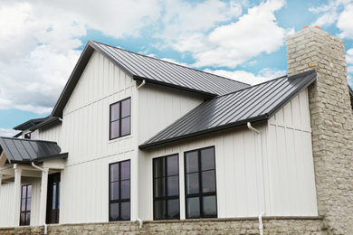 Large cottage white two-story concrete fiberboard exterior home idea in Other with a metal roof