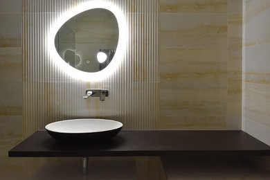 Inspiration for a large modern bathroom in Manchester with flat-panel cabinets, a built-in bath, porcelain tiles, porcelain flooring, an integrated sink, solid surface worktops and a hinged door.