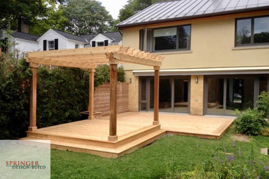 Diseño de terraza minimalista grande en patio trasero con pérgola