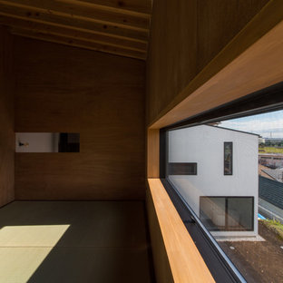 Idee per una camera da letto stile loft etnica di medie dimensioni con pareti bianche, pavimento in tatami, stufa a legna, cornice del camino in cemento e pavimento beige