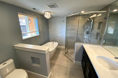 Example of a large transitional single-sink bathroom design in Other with shaker cabinets, a one-piece toilet, gray walls, an undermount sink, a hinged shower door and a built-in vanity