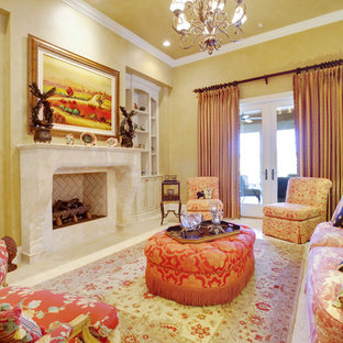 Imagen de salón mediterráneo con paredes amarillas y chimenea tradicional