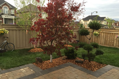 Inspiration for a mid-sized traditional full sun backyard brick formal garden in Toronto.