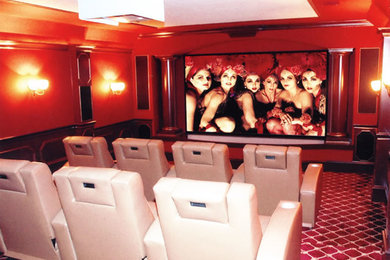Large enclosed carpeted home theater photo in Indianapolis with red walls and a projector screen