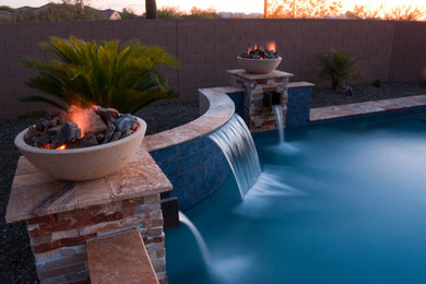 Imagen de piscina natural de estilo americano de tamaño medio a medida en patio trasero con paisajismo de piscina y adoquines de piedra natural