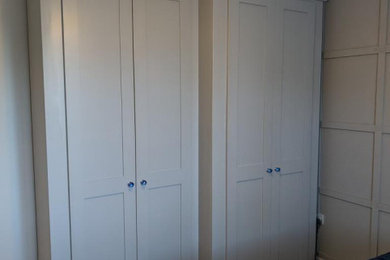 Design ideas for a medium sized contemporary standard wardrobe in Buckinghamshire with shaker cabinets, grey cabinets, carpet and beige floors.