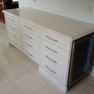 Contempory white shaker drawers & false drawers to unify cabinets.