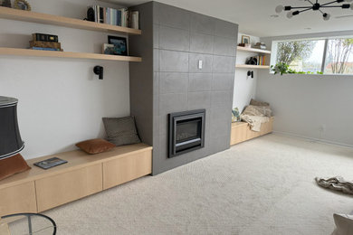 Large transitional carpeted and gray floor basement photo in Seattle with white walls and a tile fireplace