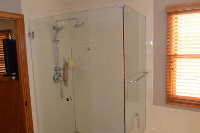 Example of a large master gray tile and ceramic tile porcelain tile bathroom design in Columbus with a one-piece toilet, an undermount sink, granite countertops and a hinged shower door