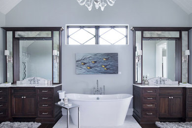 Inspiration for a transitional gray tile and marble tile dark wood floor and brown floor bathroom remodel in Other with dark wood cabinets, a two-piece toilet, gray walls, an undermount sink, marble countertops and a hinged shower door