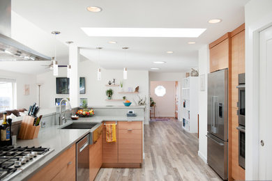 Photo of a mid-sized contemporary single-wall eat-in kitchen in Boise with flat-panel cabinets, medium wood cabinets, quartzite benchtops, with island, grey benchtop, an undermount sink, green splashback, glass tile splashback, stainless steel appliances, vinyl floors and brown floor.