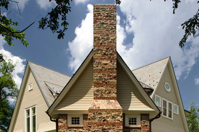 Mid-sized elegant beige two-story brick gable roof photo in New York