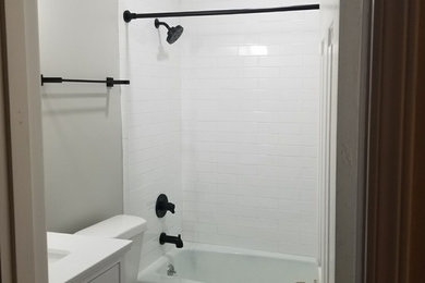 Bathroom - small transitional kids' white tile and subway tile bathroom idea in Birmingham with flat-panel cabinets, white cabinets, a two-piece toilet, gray walls, an undermount sink, quartz countertops and white countertops