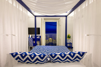Immagine di una grande camera matrimoniale mediterranea con pareti bianche, pavimento con piastrelle in ceramica, pavimento blu e soffitto a volta