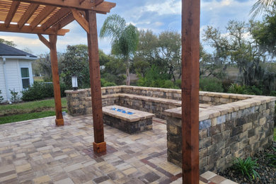 Diseño de patio ecléctico de tamaño medio en patio trasero con adoquines de hormigón y pérgola