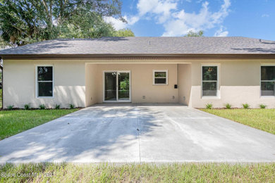 Trendy beige one-story house exterior photo in Orlando with a shingle roof and a brown roof